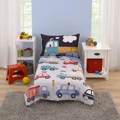 a child's bed with cars and trucks printed on the comforter, along with two nightstands