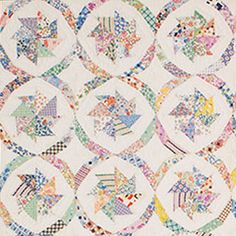 a white quilt with many circular designs on the front and back, all in different colors