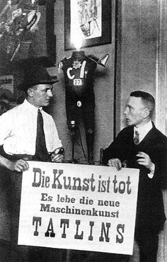 two men holding a sign in front of a mannequin wearing a top hat