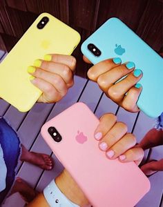 three people holding up their iphones in different colors