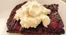 a piece of steak with whipped cream on top