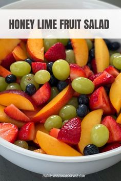 a white bowl filled with sliced fruit and text overlay reads honey lime fruit salad