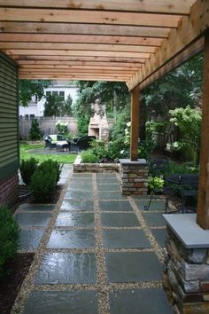 an outdoor patio with stone walkway and pergolated area