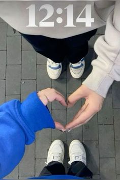 two people making a heart shape with their hands on the ground in front of them