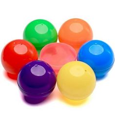 several different colored plastic balls on a white background