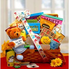 a teddy bear is sitting in a basket filled with books and other things to read