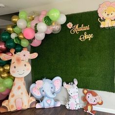 an elephant, giraffe and monkey themed birthday party with balloon decorations on the wall