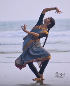 a woman doing yoga on the beach near the ocean