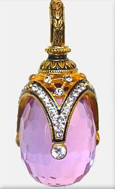 a pink and gold pendant with diamonds on it