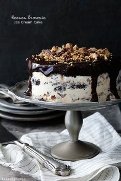 an image of a cake on a plate with chocolate and nuts in the top layer