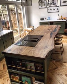 a kitchen island made out of wood with bookshelves in the center and an open window