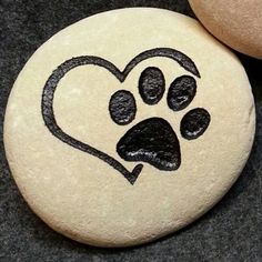 two rocks with designs on them and one has a dog's paw in the shape of a heart