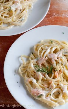 two white plates filled with pasta and shrimp