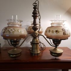 three lamps sitting on top of a wooden table