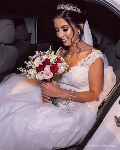 a bride sitting in the back seat of a car with her bouquet and tiara