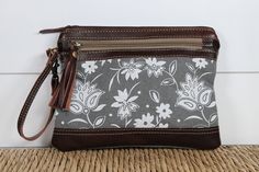 Small Pouch / Wristlet Bag This unique, upcycled canvas floral pouch / wristlet is ADORABLE and includes 7 inch leather wristlet strap. Fully lined interior and zipper top closure. It is perfect for everyday use to hold cell phone, keys, etc! A great combination of sustainable fashion and boho chic style! Measurements: Width: 9.5 in Height: 7.5 in Handle Height: 7 in Materials: Leather Canvas Orders ship within 1 business day as orders placed! Since each bag is handcrafted, colors, stitching, im Upcycled Purse, Everyday Purse, Canvas Purse, Floral Bags, Small Pouches, One Bag, Small Crossbody Bag, Leather Wristlet, Small Crossbody