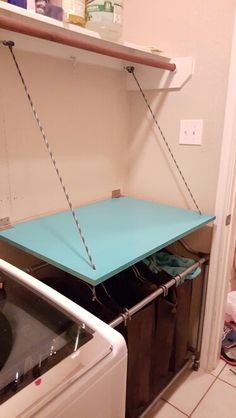 a blue table sitting on top of a dryer next to a washer and dryer