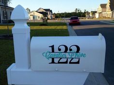 a white mailbox with the name danielle drive painted on it and a car parked in front