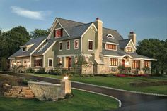 a large house with lots of windows on the front and side of it, surrounded by lush green grass