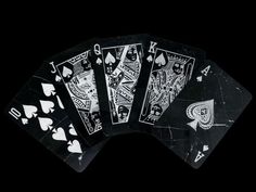 four black and white playing cards in the dark