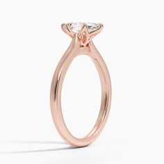 a rose gold engagement ring with an oval cut diamond in the center, on a white background