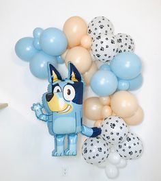 a blue dog balloon with paw prints on it next to balloons and confetti