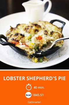 lobster shepherd's pie on a white plate with a cup and saucer next to it