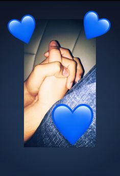 two hands holding each other with blue hearts above them