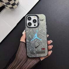 a woman holding up her air jordan phone case