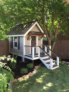 a small house in the yard with stairs leading up to it