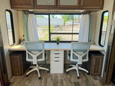 the interior of a travel trailer with two desks