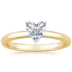 a heart shaped diamond engagement ring in yellow gold with a single stone on the band