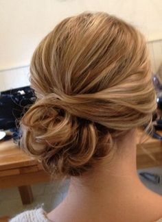 the back of a woman's head with hair pinned into a low updo