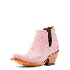 a pink cowboy boot with an embroidered design on the side and wooden heel, in front of