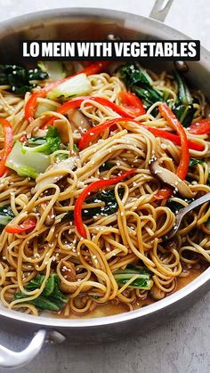 a pan filled with noodles and vegetables on top of a table