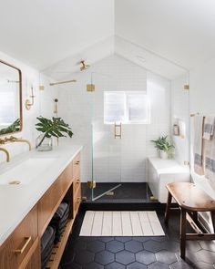 a bathroom with black and white tile flooring and wooden cabinetry, along with an open shower