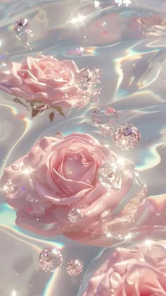 three pink roses floating in water with bubbles on the bottom and some diamonds around them