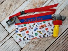 a personalized bag with construction tools on it and a name tag hanging from the front