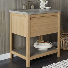 a bathroom vanity with a sink, mirror and vase on it's side table