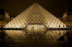 the pyramid is lit up at night with its reflection in the water