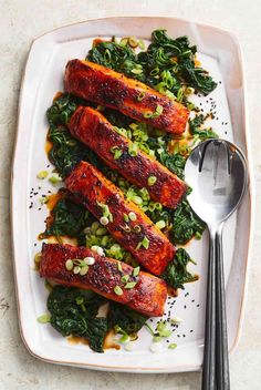 salmon and greens on a plate with a spoon