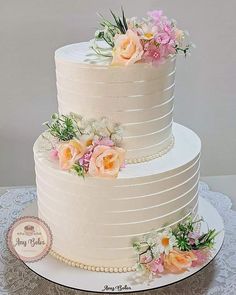 there is a three layer cake with flowers on it