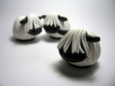 three small black and white sheep figurines sitting next to each other