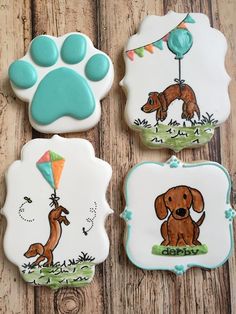 three decorated cookies with dogs on them and a balloon in the shape of a dog