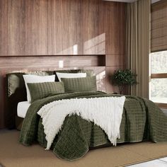 a bed with green and white bedspread in a bedroom