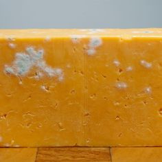 a block of cheese sitting on top of a wooden table