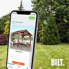 an image of a cell phone with the app built on it in front of some trees