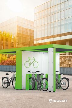 two bicycles are parked in front of a green box