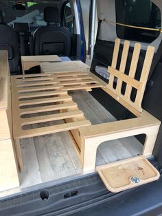 the back end of a van with wooden furniture in it