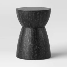 a small black stool sitting on top of a white floor